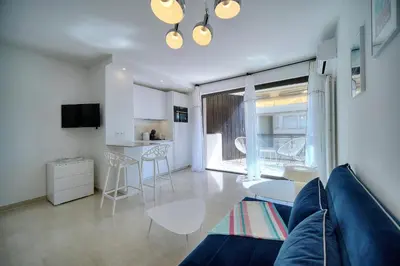 a living room with a blue couch and a kitchen at REF 1745 - Cannes Center - Studio for rent in Cannes