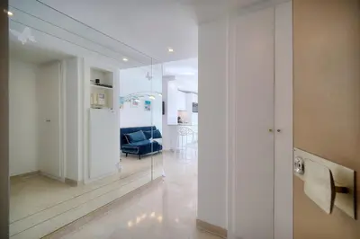 a living room with a blue couch and a mirror at REF 1745 - Cannes Center - Studio for rent in Cannes