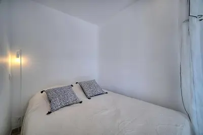 a bed in a white room with two pillows on it at REF 1745 - Cannes Center - Studio for rent in Cannes