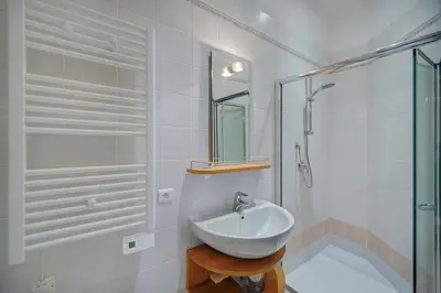 a white bathroom with a sink and a shower at REF 1320 - Cannes Center - Apartment for rent in Cannes