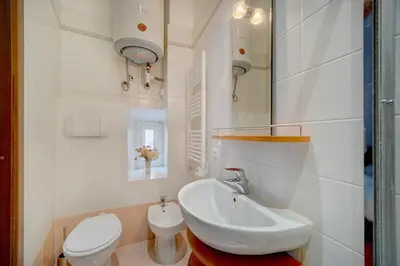 a white bathroom with a sink and a toilet at REF 1320 - Cannes Center - Apartment for rent in Cannes