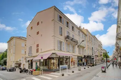 a tall building on a city street with people walking at REF 1320 - Cannes Center - Apartment for rent in Cannes