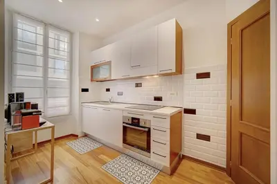 a kitchen with white cabinets and a stove top oven at REF 1320 - Cannes Center - Apartment for rent in Cannes