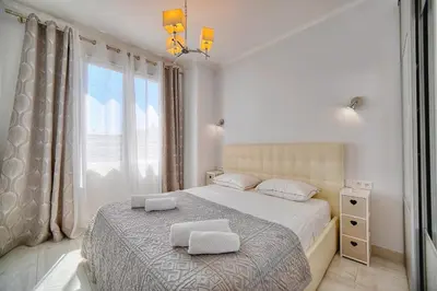 a bedroom with a bed with two pillows on it at REF 1477 - Apartment for rent in Cannes