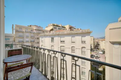 a balcony with a table and a view of a building at REF 1477 - Apartment for rent in Cannes