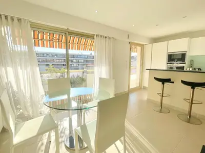a kitchen and dining room with a glass table and chairs at PR Croisette, by Welcome to Cannes in Cannes