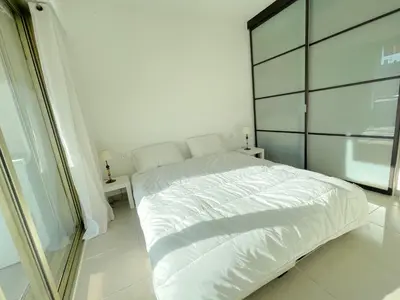 a white bed in a white bedroom with a window at PR Croisette, by Welcome to Cannes in Cannes