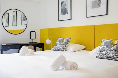 a bedroom with two beds with a yellow headboard at Palais Azur in Cannes