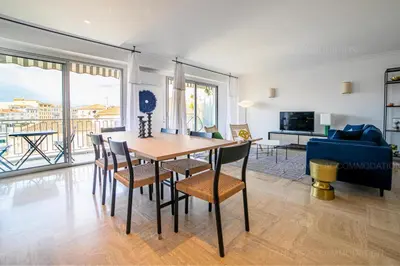 a dining room with a table and chairs and a couch at Palais Azur in Cannes