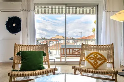 a living room with two chairs and a large window at Palais Azur in Cannes