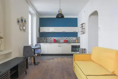 a living room with a yellow couch and a kitchen at Studio Mimosa - Welkeys in Cannes