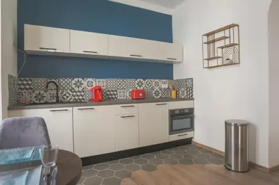 a kitchen with white cabinets and a table at Studio Mimosa - Welkeys in Cannes