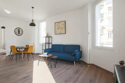 a living room with a blue couch and a table at Appartement Palme d'Or - Welkeys in Cannes