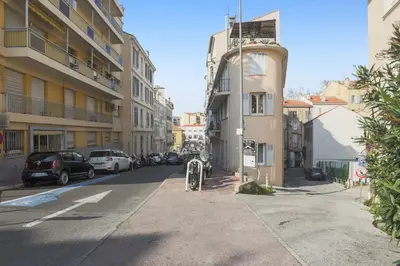 a street with cars parked on the side of a building at Appartement Palme d'Or - Welkeys in Cannes