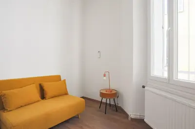 a yellow couch in a room with a window at Appartement Palme d'Or - Welkeys in Cannes
