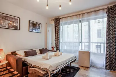 a bedroom with a bed and a large window at Studio Merle - Welkeys in Cannes