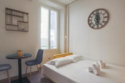a bedroom with a bed and a clock on the wall at Studio Soleil - Welkeys in Cannes