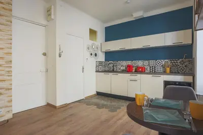 a kitchen with a table and a blue wall at Studio Soleil - Welkeys in Cannes