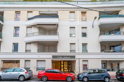 a building with cars parked in front of it at Appartement Libériade - Welkeys in Cannes