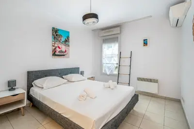 a bedroom with a large white bed with towels on it at Appartement Libériade - Welkeys in Cannes