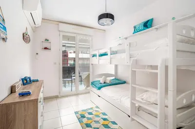 a bedroom with bunk beds and a desk at Appartement Libériade - Welkeys in Cannes