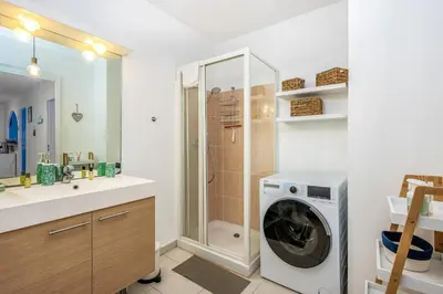 a bathroom with a washing machine and a shower at Appartement Libériade - Welkeys in Cannes