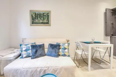 a room with a bed and a table and a desk at Studio Lys - Welkeys in Cannes