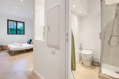a bathroom with a shower and a toilet and a bedroom at Studio Lys - Welkeys in Cannes