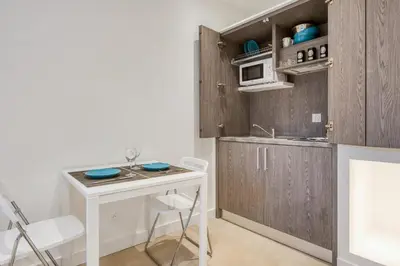 a small kitchen with a white table and a counter at Studio Lys - Welkeys in Cannes