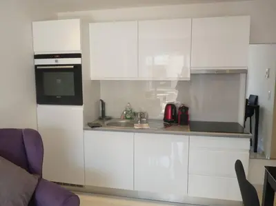 a white kitchen with a sink and a microwave at Two bedroom apartment next to the Croisette in Cannes a short walk to the Palais des Festivals - 1961 in Cannes