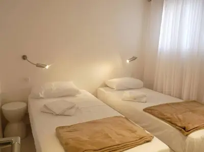 two beds in a small room with white walls at Two bedroom apartment next to the Croisette in Cannes a short walk to the Palais des Festivals - 1961 in Cannes