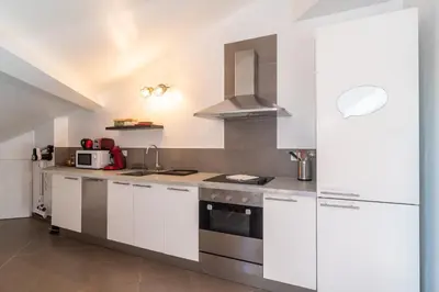 a kitchen with white cabinets and a stove top oven at Le Laeti - 600m plage - Verrière Côte d'Azur in Cannes