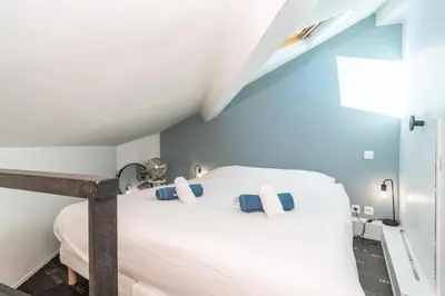 a bedroom with a white bed with blue walls at Le Laeti - 600m plage - Verrière Côte d'Azur in Cannes