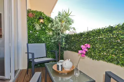 a table with a vase of flowers on a patio at Le Flore - Appartement neuf - Cannes Center in Cannes