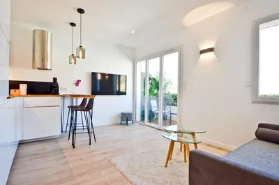 a kitchen and living room with a glass table at Le Flore - Appartement neuf - Cannes Center in Cannes