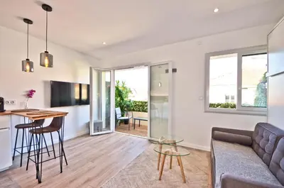 a living room with a couch and a table at Le Flore - Appartement neuf - Cannes Center in Cannes