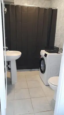 a bathroom with a washing machine and a sink at Appartement proche croisette avec parking et climatisation in Cannes