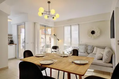 a dining room with a table and a couch at Beau 2 chambres TERRASSE, COEUR DU SUQUET-entre Port et Plages A2B238 in Cannes
