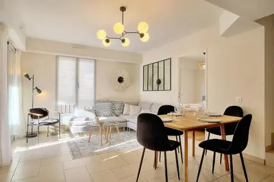 a dining room and living room with a table and chairs at Beau 2 chambres TERRASSE, COEUR DU SUQUET-entre Port et Plages A2B238 in Cannes