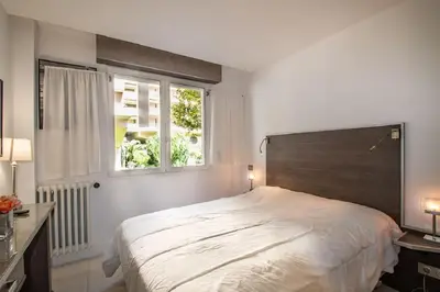 a bedroom with a large bed and a window at Croisette: 2BDR Apartment in Cannes