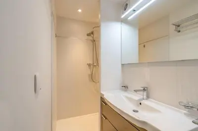 a white bathroom with a sink and a shower at Croisette: 2BDR Apartment in Cannes