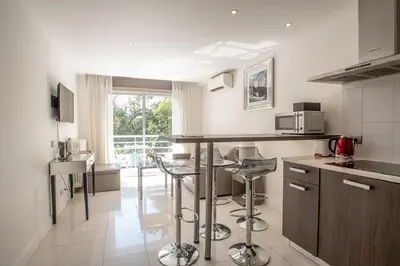 a kitchen with a counter and stools in it at Croisette: 2BDR Apartment in Cannes