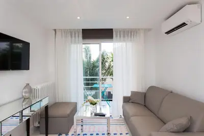 a living room with a couch and a sliding glass door at Croisette: 2BDR Apartment in Cannes