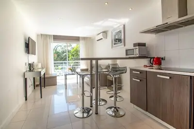 a kitchen with a counter and stools in it at Croisette: 2BDR Apartment in Cannes