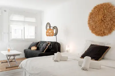 a white bedroom with a large bed and a couch at 