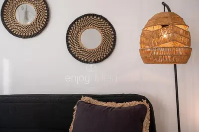 a living room with a couch and two wicker mirrors at 