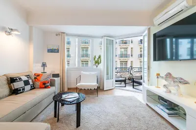 a living room with a couch and a tv at 2-Bedroom Apartment with Terrace and Side Sea View in Cannes