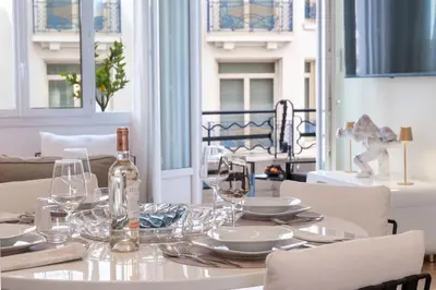 a white table with glasses and a bottle of wine at 2-Bedroom Apartment with Terrace and Side Sea View in Cannes