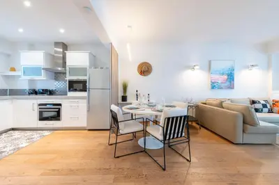a kitchen and living room with a table and a couch at 2-Bedroom Apartment with Terrace and Side Sea View in Cannes