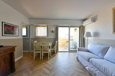 a living room with a couch and a table at L'ALIZEE avec jolie terrasse vue sur la ville, charmant studio dans le centre de Cannes in Cannes